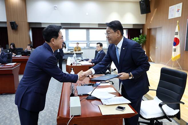 증인선서 후 선서문을 김교홍(오른쪽) 위원장에게 전달하는 김태흠 지사.