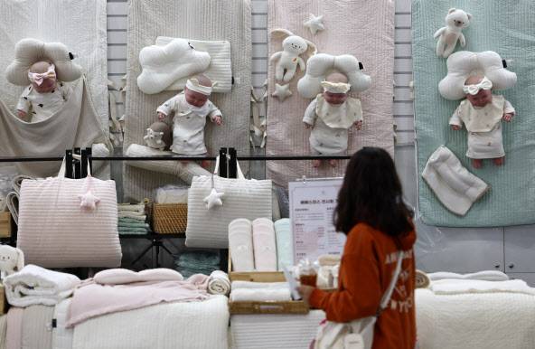 5일 서울 코엑스에서 열린 코베 베이비페어에서 관람객이 영유아 이불 등 상품을 살피고 있다 .(사진=연합뉴스)