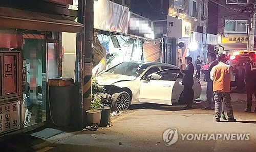 25일 오후 8시 30분쯤 서울 용산구 한남동 순천향대병원 인근에서 50대로 추정되는 여성 A씨가 몰던 차량이 골목의 한 가게로 돌진해 있다. [독자 제공=연합뉴스]