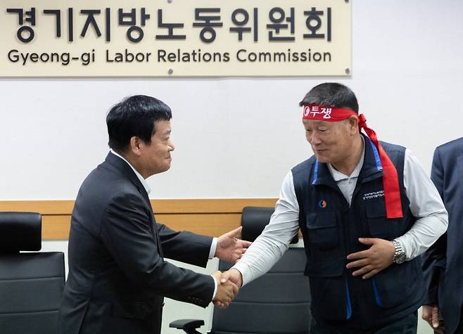 김기성 경기도버스운송사업조합 이사장(왼쪽)과 이기천 경기도버스노조협의회 의장이 25일 오후 경기도 수원시 장안구 경기지방노동위원회에서 열린 경기지역자동차노동조합 노동쟁의 조정신청 사건에 대한 조정회의에서 협상 타결 후 악수하고 있다. /사진=뉴스1