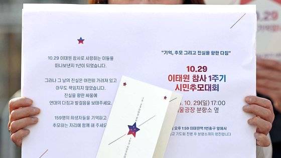 18일 오전 서울 용산 대통령실 앞에서 열린 이태원 참사 1주기 기자회견에서 한 유가족이 1주기 시민추모대회 초대장을 들고 눈물을 흘리고 있다. 연합뉴스