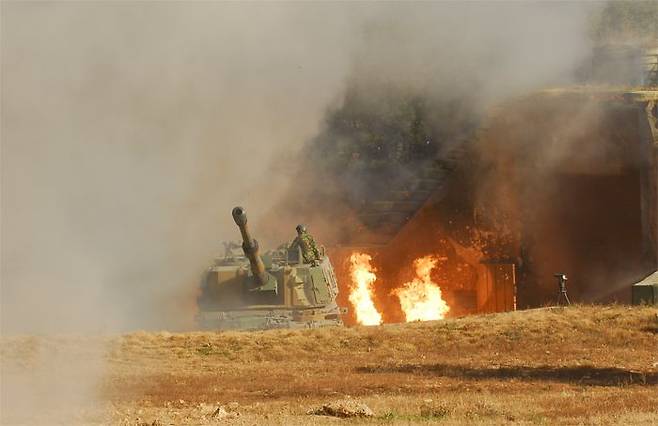 연평도 포격 도발 사건 당시 해병대 연평 부대 K-9 진지에서 한 해병대원이 북한의 기습 포탄 공격 속에서 반격 태세를 갖추고 있다. 북한군 포탄으로 발생한 화염과 연기가 당시 상황을 말해준다. /해병대
