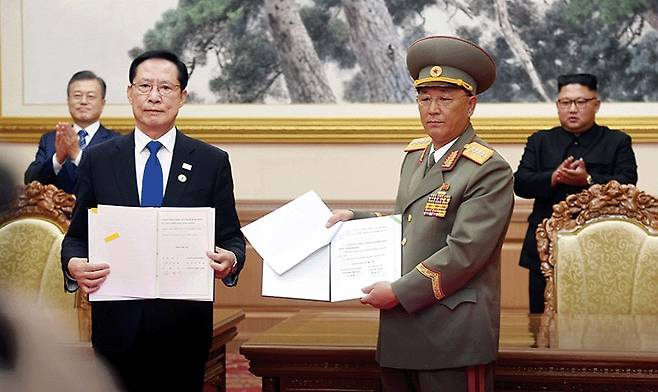 2018년 9월 19일 평양 백화원 영빈관에서 송영무 전 국방부 장관과 노광철 전 북한 인민무력상이 막 체결한 ‘9·19 남북군사합의’ 문서를 들여보이고 있다. 왼쪽 뒤편은 문재인 전 대통령. 뒤편 오른족은 김정은 북한 국무위원장. /뉴시스