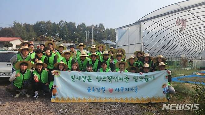 [서울=뉴시스] 금호건설 임직원이 사곡리마을에서 일손 돕기를 한 후 단체 기념촬영을 하고 있다. (사진=금호건설 제공)