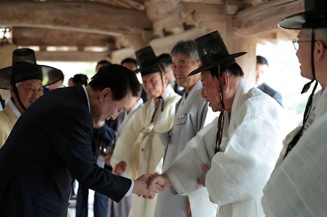 윤석열 대통령이 27일 오후 경북 안동 병산서원에서 열린 유림간담회에 입장하며 참석자들과 인사하고 있다. 이날 간담회에서 윤 대통령은 자신의 문중인 파평 윤씨 집안이 안동 유림들과 오랜 세월 인연을 맺은 점을 언급하며 “고향에 온 것 같고 마음이 아주 편안하다”고 했다./대통령실