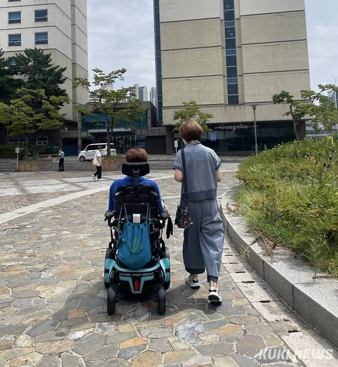 서강대학교 캠퍼스에서 함께 산책하는 김정환군과 그의 어머니. 어머니는 김군이 20세가 된 이후 더 이상 아들의 수업에 따라 나서지 않는다. 아들의 10대 시절엔 어디든 동행해야 했다. 고기능 휠체어를 구한 뒤 어머니에게 ‘자유’가 생겼다. 사진=박선혜 기자