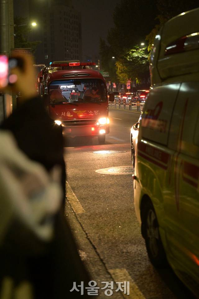 한 시민이 소방차와 구급차로 혼란한 현장을 카메라에 담고 있다.