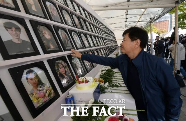 10.29 이태원 참사 유가족이 16일 오후 서울 중구 서울광장 분향소 앞에서 10.29 이태원 참사 1주기 집중 추모 주간 선포 및 시민추모대회 시민 참여를 호소하는 기자회견에 참석해 분향소에 걸린 영정사진을 쓰다듬고 있다. /서예원 인턴기자