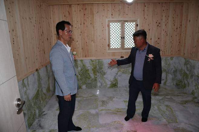 금왕읍 호산1리 마을회관 내 찜질방을 둘러보고 있는 조병옥 군수와 장경순 이장. /충북 음성군 제공