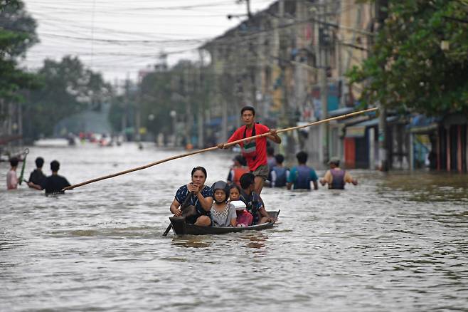 미얀마 남부 바고 지역 주민들이 지난 9일(현지시간) 폭우로 침수된 거리를 지나고 있다./AFP 연합뉴스