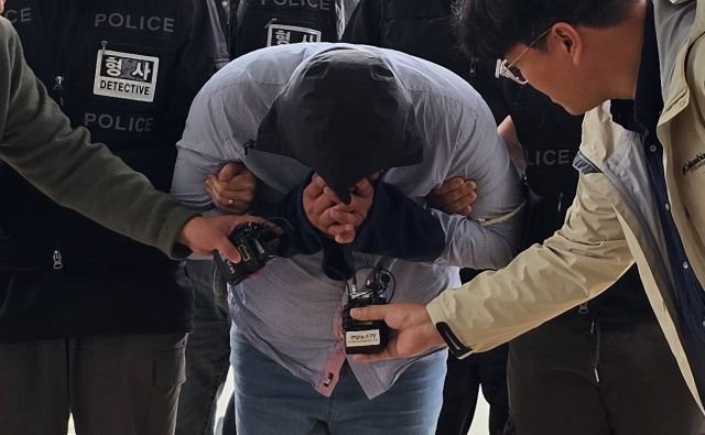 지난달 23일 70대 택시기사를 살해하고 태국으로 도주한 혐의를 받는 40대 남성이 24일 충남 아산경찰서로 압송되는 모습. 연합뉴스