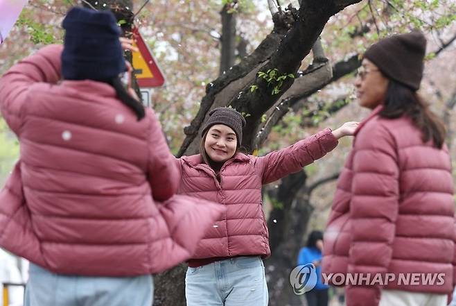 한국을 방문한 태국 관광객이 패딩을 입고 사진을 찍고 있다. 자료사진. [사진출처 = 연합뉴스]