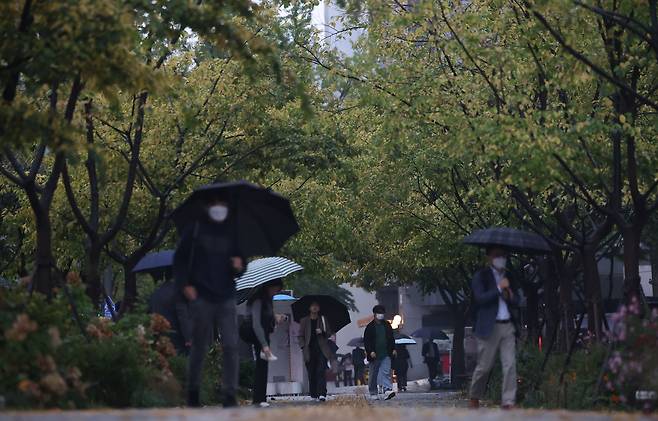 서울 광화문광장에서 시민들이 우산을 쓰고 걸어가고 있다. [연합]