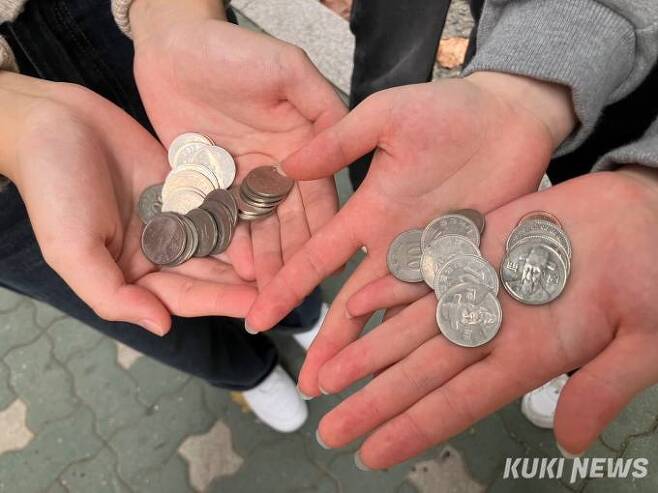지난 1일 길거리에서 만난 김희수(15)양과 김모(15)양이 지갑에 갖고 있던 동전을 꺼내 보여 주고 있다. 사진=이예솔 기자