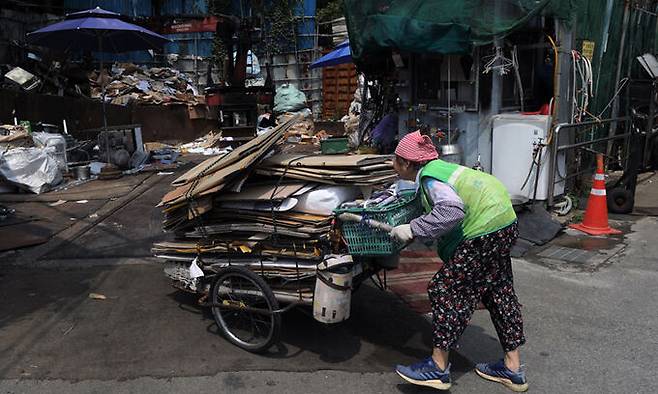 서울 서초구 서초대로 인근 고물상에서 한 할머니가 수거한 폐지를 옮기고 있다. 뉴시스