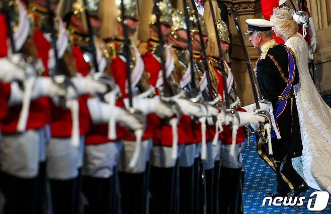 찰스 3세 영국 국왕 부부가 연설 이후 의장대의 사열을 받으며 의회를 떠나고 있다. ⓒ AFP=뉴스1 ⓒ News1 박형기 기자