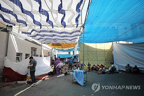 가자지구의 한 병원 건물 밖에 모여 있는 피란민들 [AFP 연합뉴스 자료 사진. 재판매 및 DB 금지]