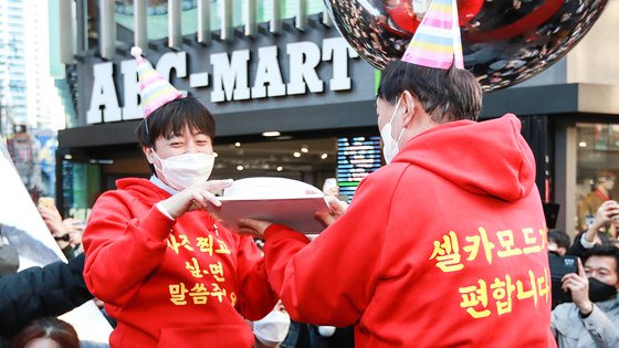 지난 대선 기간인 2021년 12월 부산 서면 시내 거리에서 국민의힘 윤석열 대선 후보(오른쪽)와 이준석 대표가 앞 뒷면에 노란색 글씨로 '사진 찍고 싶으면 말씀 주세요', '셀카 모드가 편합니다'라고 적힌 빨간색 후드티를 입고 유세를 하고 있다. 연합뉴스