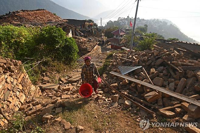 지진으로 무너진 네팔 북서부 산간 마을 (자자르콧 AFP=연합뉴스) 네팔 북서부 카르날리주 자자르콧의 산간 마을 주민이 6일(현지시간) 강진으로 무너진 집과 축대를 지나고 있다. 규모 5.6의 이번 강진으로 이 일대 주민 최소 157명이 숨졌다. 2023.11.06 kjw@yna.co.kr