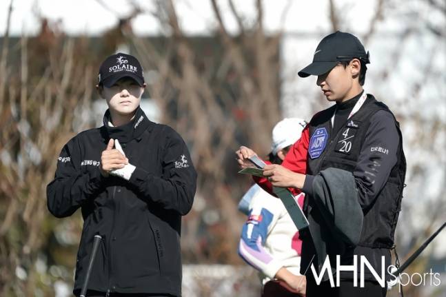 캐디로 변신한 김시원이 10일 열린 SK쉴더스 Sk텔레콤 챔피언십 1라운드에서 야디지북을 살펴보고 있다.(사진=춘천, 박태성 기자)