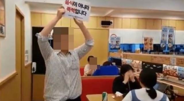 DxE의 한 조직원이 서울 시내 음식점에 들어가 구호를 외치고 있다. 트위터 캡처