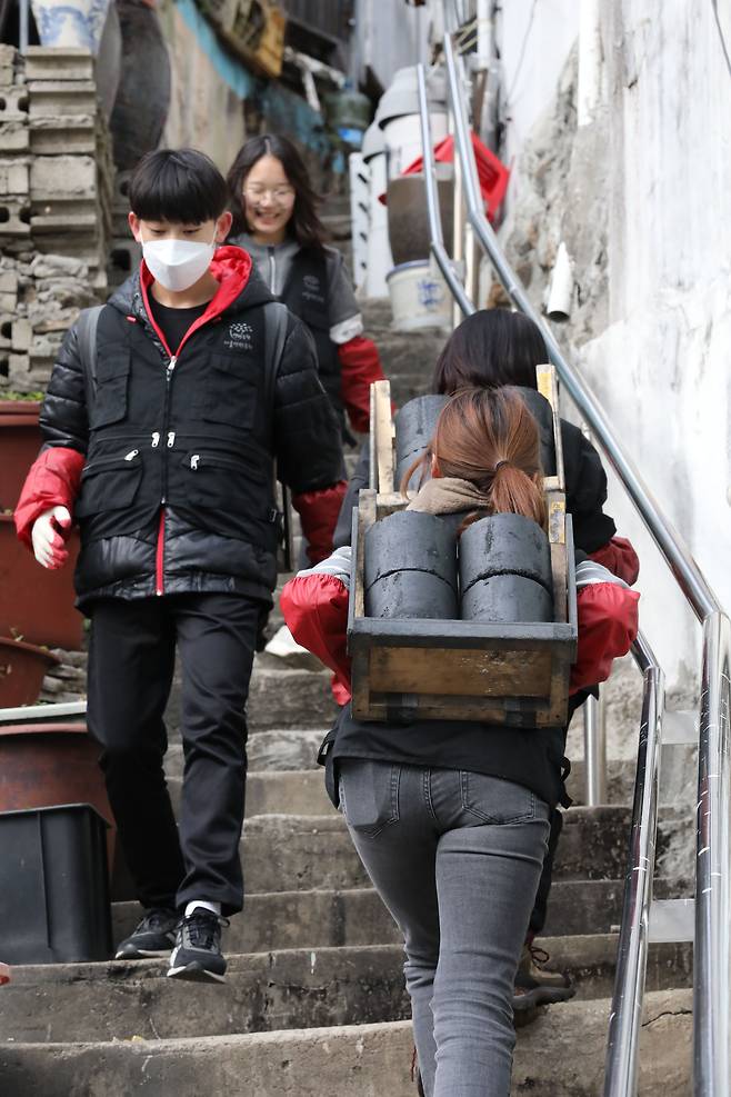 여성 자원봉사자들이 지게를 매고 연탄을 전하고 있다. 기상청에 따르면 이날 서울 최저기온은 영하3도를 나타냈고, 올 가을 들어 처음으로 영하권의 추위를 보였다./박성원 기자