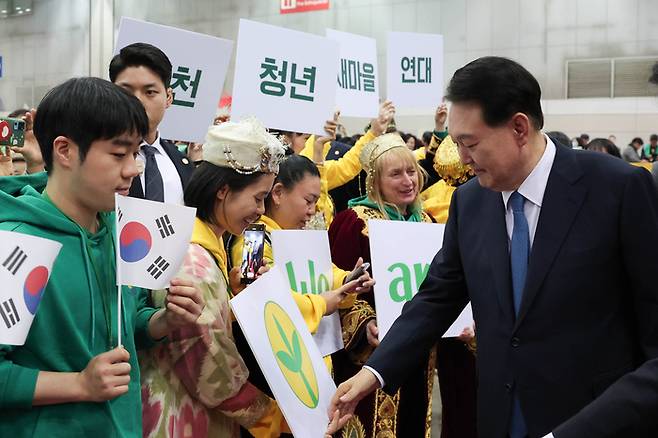 윤석열 대통령이 12일 경기 고양시 킨텍스에서 열린 2023 전국새마을지도자대회 ‘청년의 약속’ 선포식에 입장하며 청년들과 인사하고 있다. 대통령실 제공