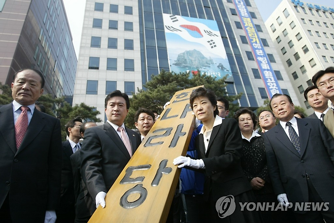 박근혜 전 대통령이 2004년 한나라당 비대위원장 시절 당 현판을 천막당사로 옮기는 모습