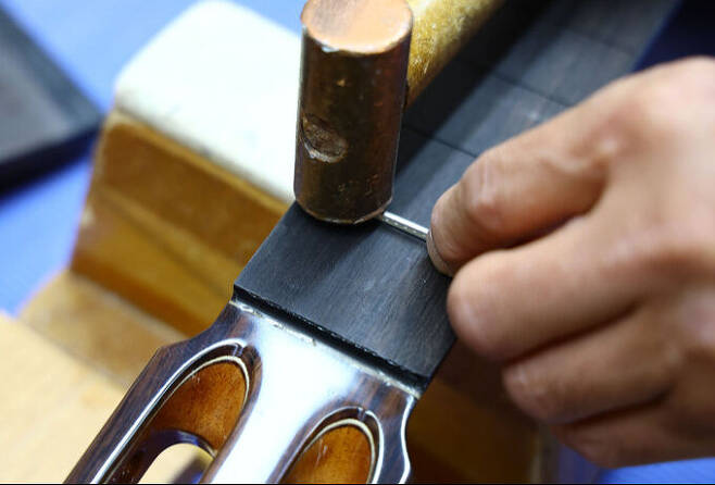 넥 부분에 금속재 프렛을 고정시키는 과정.
