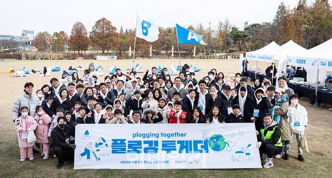 현대위아 직원 및 가족들이 11일 경기도 의왕시 왕송호수공원에서 ‘플로깅(Plogging)’ 봉사 기념 사진을 찍고 있다. (사진=현대위아)