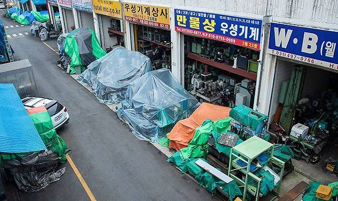 지난 11일 경기도 시흥시 시화기계유통단지 내 각 업소 앞에 방수 천막을 덮어쓴 대형 중고 기계들이 늘어서 있다. 휴·폐업하는 영세 중소기업들에서 중고 기계 매물이 쏟아지면서 업체마다 보관할 공간이 없기 때문이다. 이날 4만㎡ 규모 유통 단지에는 기계를 사러 온 사람들은 거의 없었다. /박상훈 기자