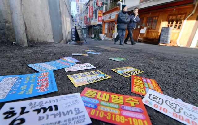 서울 명동의 골목길 바닥에 업체 이름과 등록번호가 없어 정체를 알기 힘든 불법 대부업체 대출 전단이 널려 있다. 한국일보 자료사진