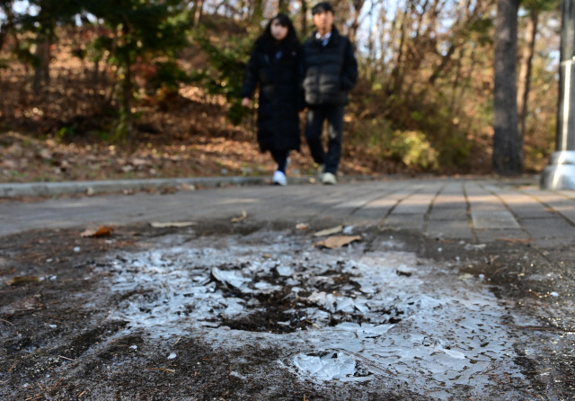 ▲ 도내 영서지역 대부분 아침 기온이 영하 이하로 떨어지며 추운 날씨를 보인 13일 춘천 후평동의 보도에 고인 물이 얼었다. 김정호