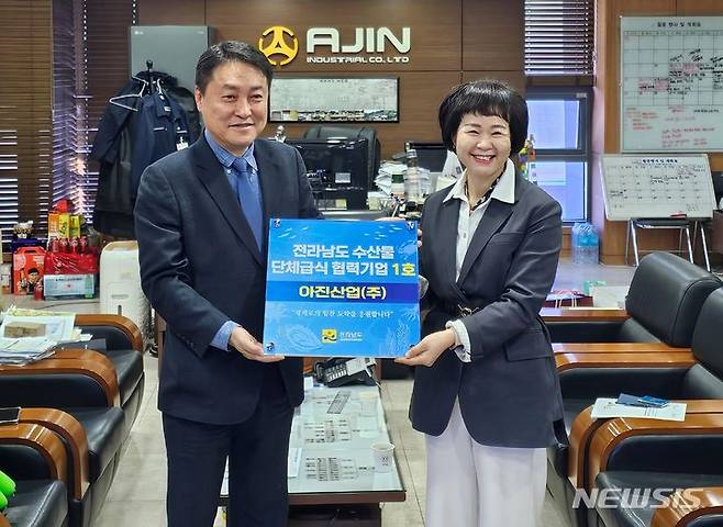 [무안=뉴시스] 전남도는 15일 경북에 소재한 아진산업㈜를 '전남도 수산물 단체급식 제1호 협력기업'으로 지정했다. 박상미 전남도 수산유통과장(오른쪽)이 지정 명패를 전달하고 있다. (사진=전남도 제공) 2023.11.15. photo@newsis.com