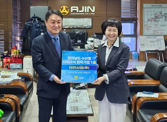 전남수산물 단체급식 협력기업 1호 지정로 아진산업 서중호 대표와 박상미 전남도 수산유통과장이 기념사진을 찍고 있다. 전라남도 제공