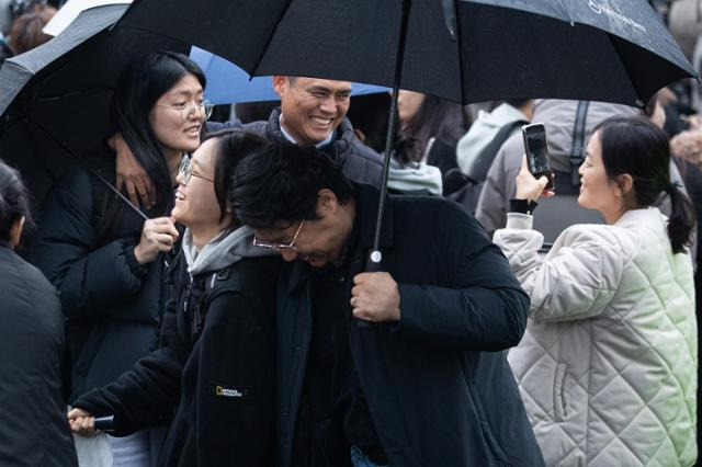 16일 서울 중구 이화여자외국어고등학교 앞에서 수능시험을 마친 수험생들이 가족의 격려를 받으며 시험장을 나서고 있다. 뉴스1