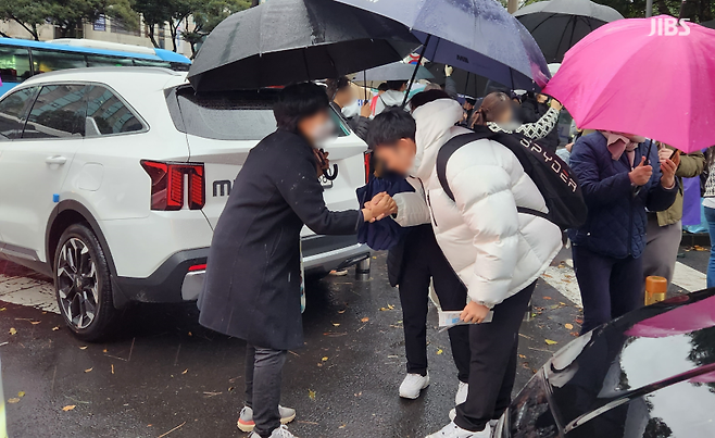 오늘(16일) 오후 수능을 마친 제주지구 제1시험장인 제주 남녕고등학교 정문 앞 현장. 교사와 수험생이 악수를 나누는 모습.(사진, 신동원 기자)