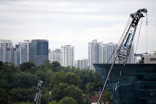 서울 시내의 한 주상복합 공사현장 크레인 너머로 주거단지가 보이고 있다./뉴스1