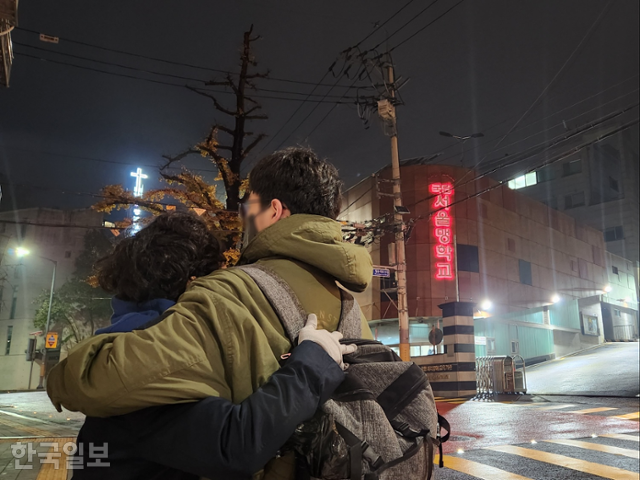 16일 오후 10시 서울 종로구 서울맹학교 앞에서 시각장애인 수험생 채모군이 어머니와 포옹하고 있다. 채군은 2024학년도 대학수학능력시험을 전국에서 마지막으로 마친 수험생이다. 김나연 기자