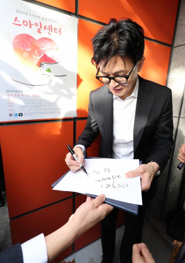 한동훈 법무부 장관이 17일 대구 수성구 스마일센터를 방문해 시민들에게 사인을 해주고 있다. 뉴시스