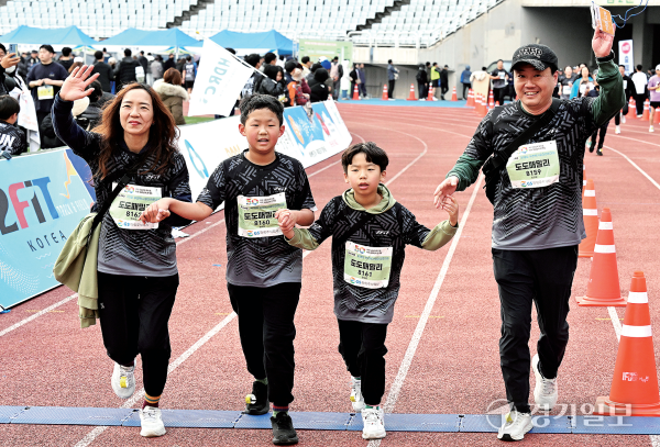 가족런 5km에 출전한 한 가족이 서로 손을 잡고 결승선을 통과하고 있다. 김시범·홍기웅기자