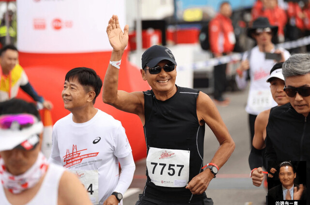 지난 19일(현지시각) 홍콩에서 열린 제1회 홍콩 주하이-마카오 대교 하프 마라톤 대회에 홍콩 영화 붐을 이끌었던 배우 저우룬파(주윤발·가운데)가 참가해 그를 응원하는 인파를 향해 손을 흔들어 보이고 있다. 소후닷컴 누리집 갈무리