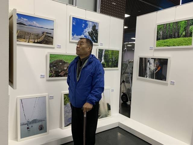 지난 17일 조인순씨가 서울시청 본관 지하1층에서 열린 작품 전시회에서 동료들의 사진 작품을 바라보고 있다. 이서현 인턴기자