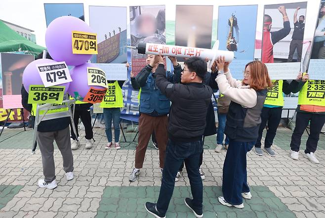 ▲ 11월9일 서울 영등포구 국회 앞에서 열린 '손해배상 20년, 하청 20년, 죽음 내몰린 20년 특별사진전 기자회견'에서 참가자들이 손해배상 가압류 풍선을 노란봉투법 모형 주사기로 터뜨리는 퍼포먼스를 하고 있다. ⓒ 연합뉴스