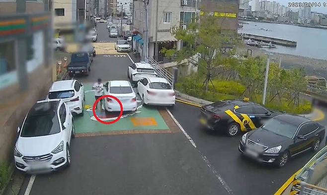 지난 9월 14일 울산 동구의 한 주택가 골목에서 40대가 서행하는 승용차에 일부러 발을 집어넣어 사고를 내고 있다. 울산경찰청 제공