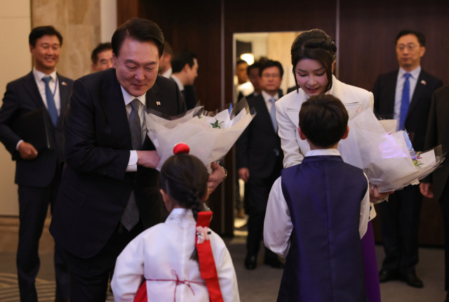 영국을 국빈방문한 윤석열 대통령과 부인 김건희 여사가 20일(현지 시간) 런던의 한 호텔에서 열린 동포 만찬 간담회에서 화동으로부터 꽃다발을 받고 있다. 런던=연합뉴스