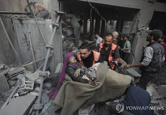 폭격을 맞은 가자지구 남부 칸 유니스의 한 건물에서 생존자를 구하는 팔레스타인 주민들 [AP 연합뉴스 자료사진. 재판매 및 DB 금지]