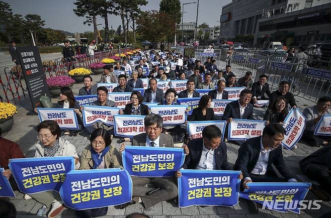 [서울=뉴시스] 정병혁 기자 = 18일 서울 용산구 전쟁기념관 앞에서 열린 전남도 의과대학 유치 촉구 집회에서 참석자들이 피켓을 들고 구호를 외치고 있다. 2023.10.18. jhope@newsis.com