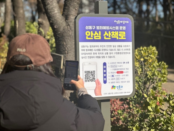 서울 성동구의 한 구민이 산책로 범죄예방시스템을 스캔하고 있다. 성동구 제공