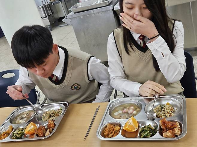 (서울=연합뉴스) 서혜림 기자 = 22일 서울 성북구 숭곡중학교 급식실에서 학생회장 조형찬 군과 부회장 한다희 양이 급식 로봇이 조리한 음식을 먹고 있다. 2023.11.22 sf@yna.co.kr